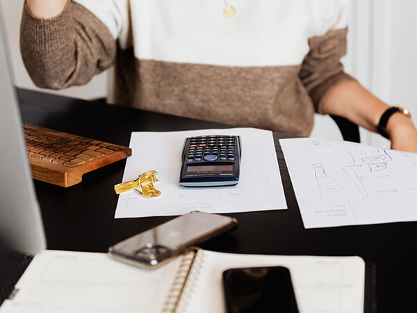 A photograph of a person's desk with a calculator and other devices - Chaos Theory | Serious Games Developer, Australia