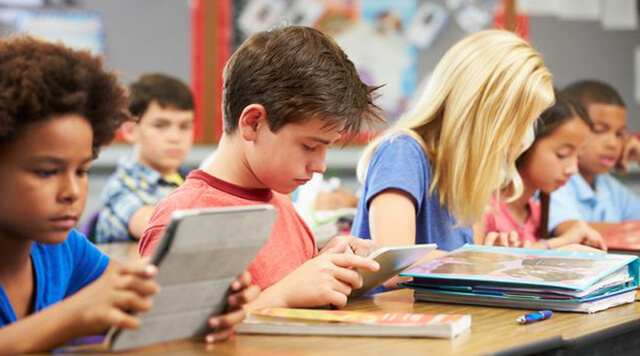 A photograph of children learning on their tablet devices - Chaos Theory | Serious Games Developer, Australia