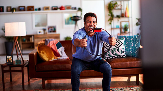 A photograph of a man playing Ringfit on a Nintendo Switch Console  - Chaos Theory | Serious Games Developer, Australia