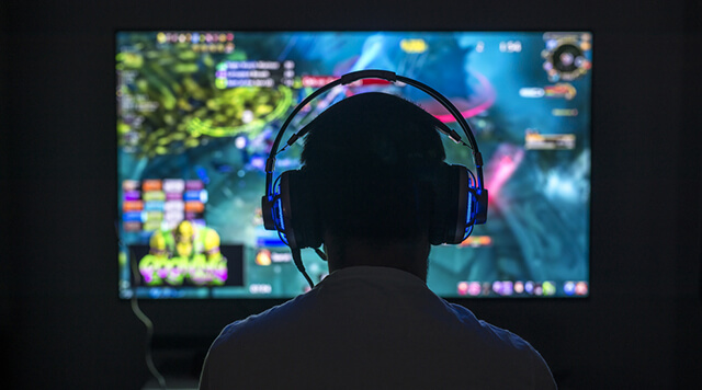 A photograph of a person playing video games with a headset on - Chaos Theory | Serious Games Developer, Australia