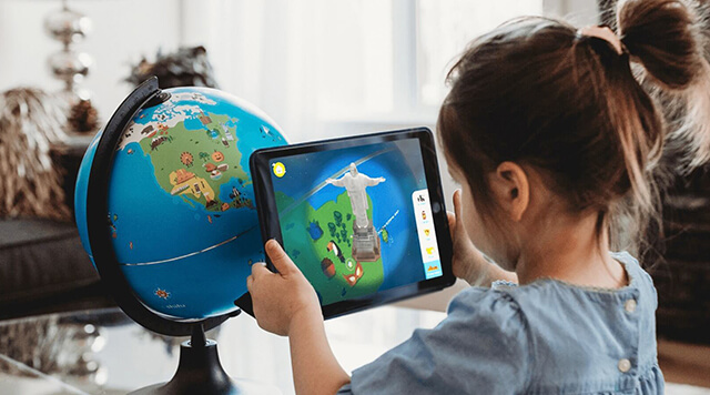 A photograph of a child playing a game on a tablet, using augmented reality to interact with items - Chaos Theory | Serious Games Developer, Australia