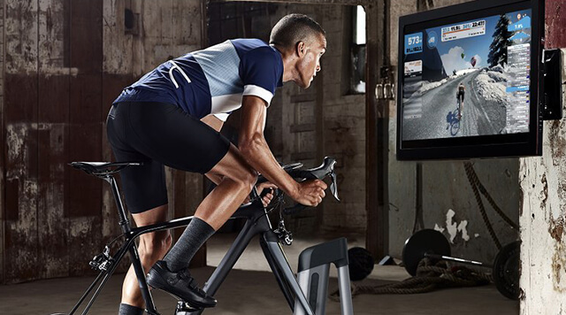 A man on a Wahoo training bicycle using the Zwift virtual training platform.  - Chaos Theory | Serious Games Developer, Australia