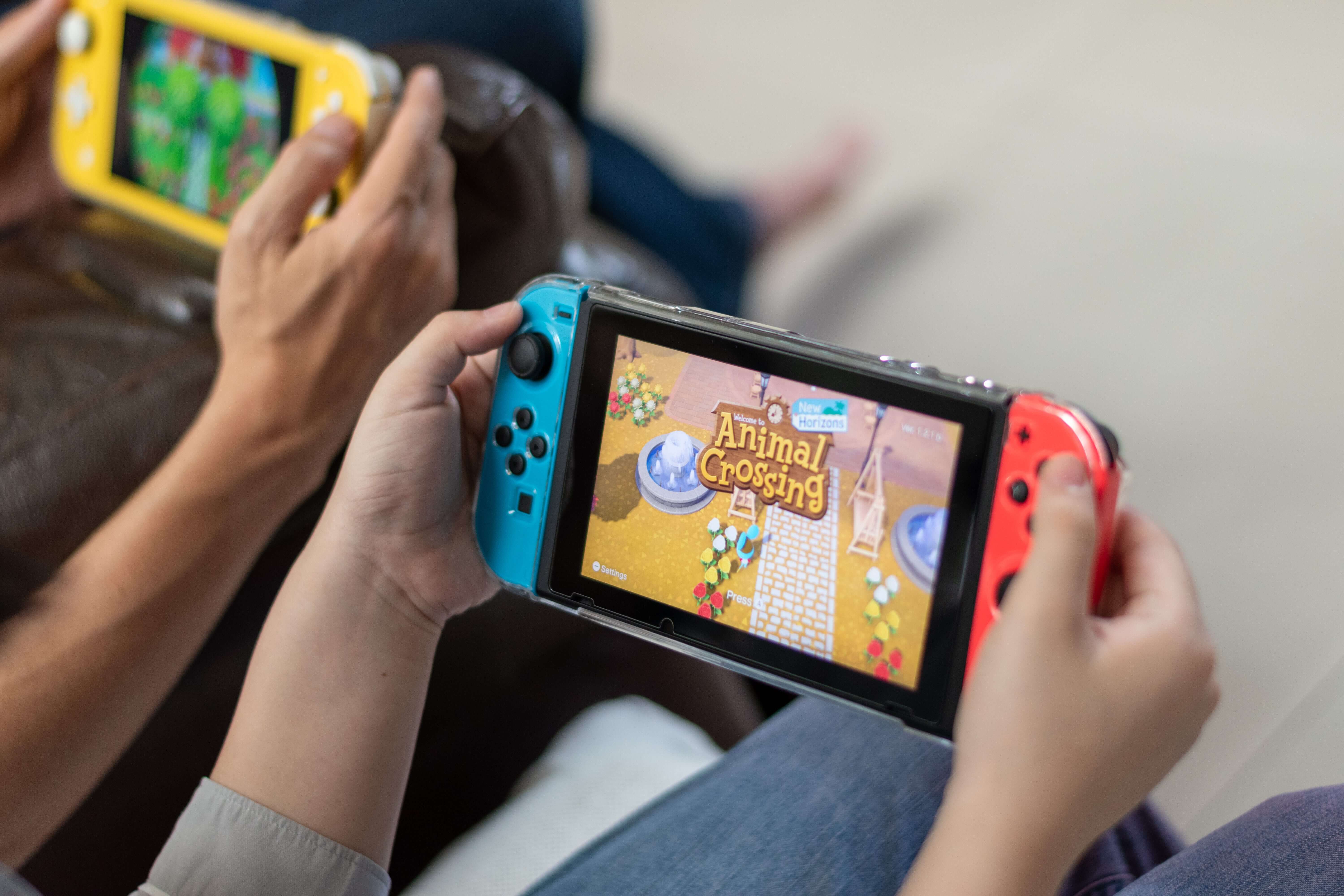 Two people playing games, on a Nintendo Switch which is an energy efficient game console reducing the environmental impact of gaming.