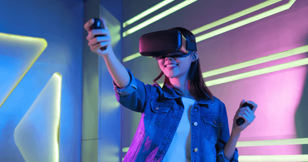 A photograph of a woman with a virtual reality headset and controllers - Chaos Theory | Serious Games Developer, Australia